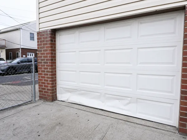 Garage door with a dented bottom section that needs replacing