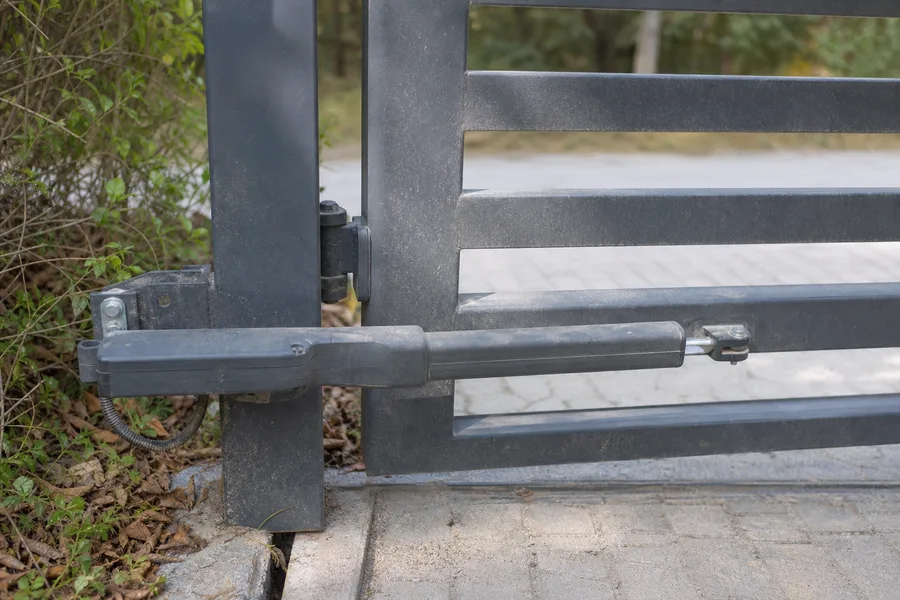 Linear-arm gate operator on the post of an aluminum driveway gate, NYC